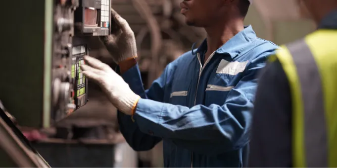 Profissional operando painel eletrônico em ambiente industrial, vestindo uniforme com tecido antiestático para evitar descargas eletrostáticas