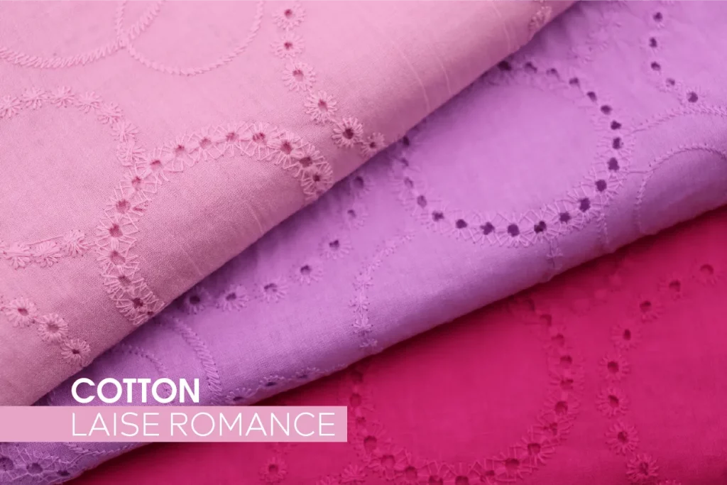 Tecido Cotton Laise Romance em tons rosa, lilás e pink, com bordados vazados em formato floral