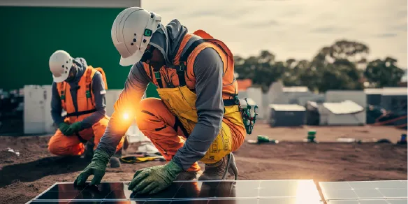 Profissionais instalando painéis solares sob o sol, usando uniformes com tecido de proteção UV para minimizar a exposição solar